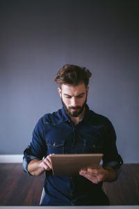 Hipster guy using digital tablet in home office