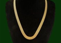 Ett brett Bismarckhalsband i guld på en svart byst.